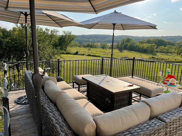 wooden deck with an outdoor living space and a view of trees