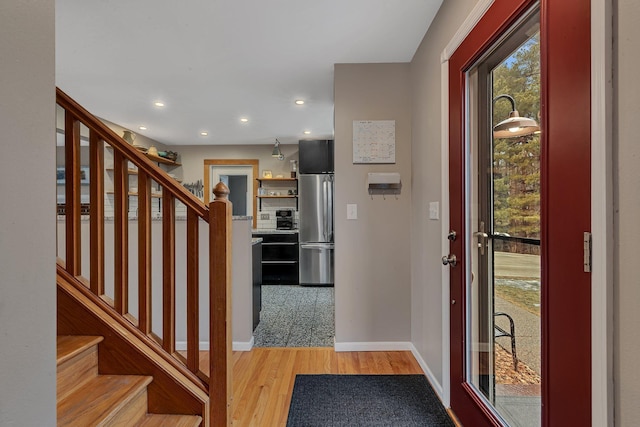 foyer with stairs, recessed lighting, light wood-style flooring, and baseboards