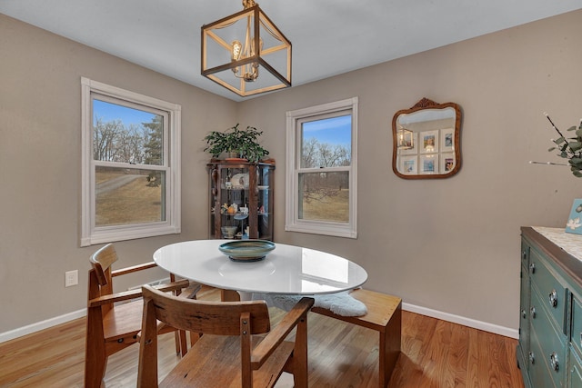 dining space featuring light wood-style flooring and baseboards