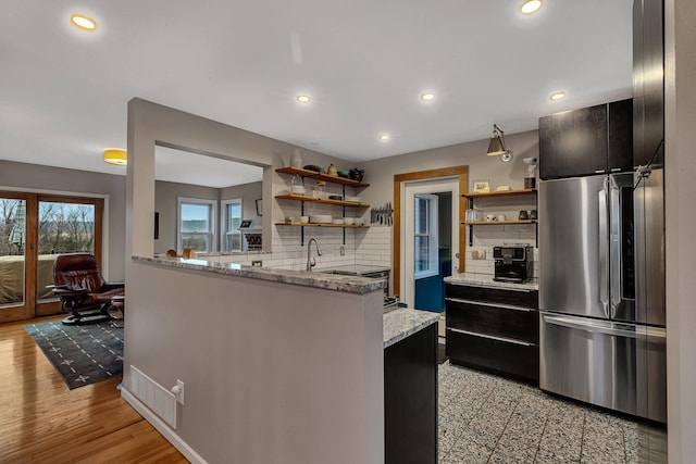 kitchen with tasteful backsplash, recessed lighting, freestanding refrigerator, and open shelves