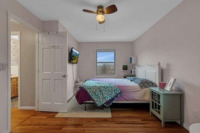 bedroom featuring ceiling fan, baseboards, and wood finished floors