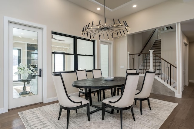 dining room featuring baseboards, stairway, recessed lighting, an inviting chandelier, and wood finished floors