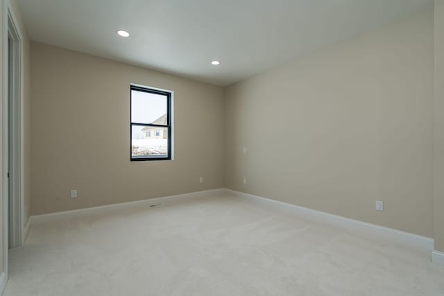 spare room with recessed lighting, baseboards, and light carpet