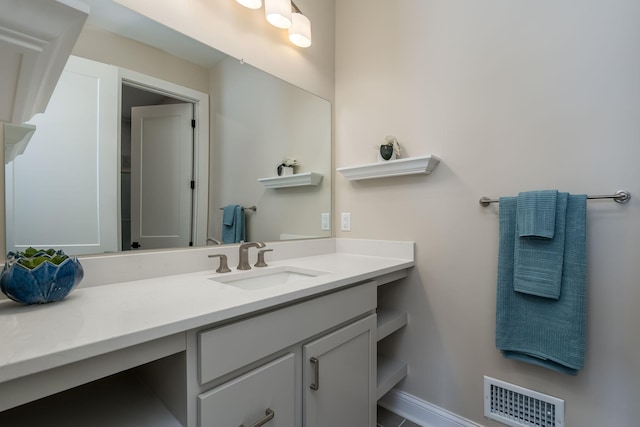 bathroom featuring visible vents, baseboards, and vanity