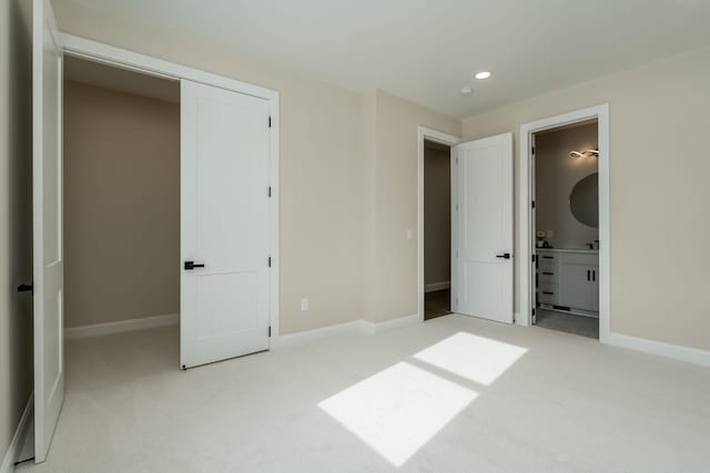 unfurnished bedroom with recessed lighting, connected bathroom, baseboards, and carpet floors