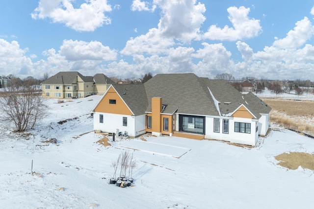 view of snow covered rear of property