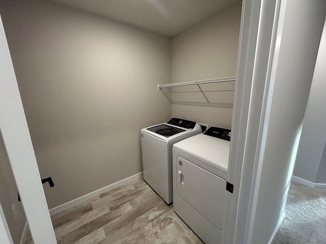 washroom featuring laundry area, baseboards, and independent washer and dryer