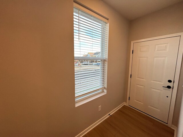 doorway to outside with baseboards and dark wood finished floors