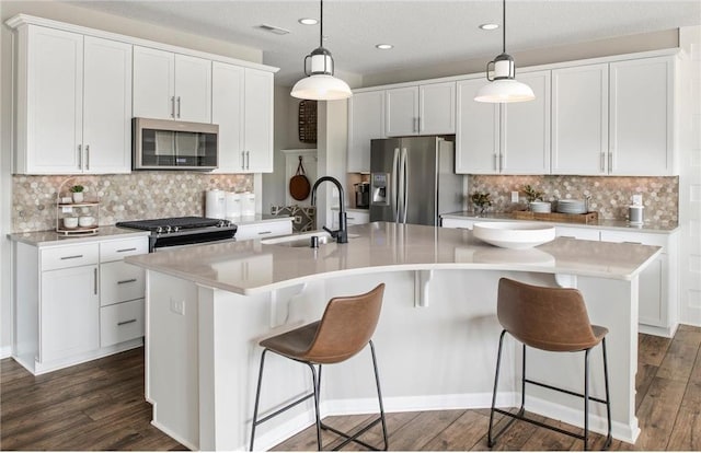 kitchen featuring visible vents, dark wood-style flooring, stainless steel appliances, white cabinetry, and a sink