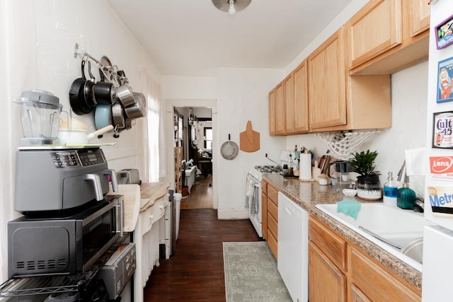 kitchen featuring white appliances, dark wood-style flooring, light countertops, light brown cabinetry, and a sink