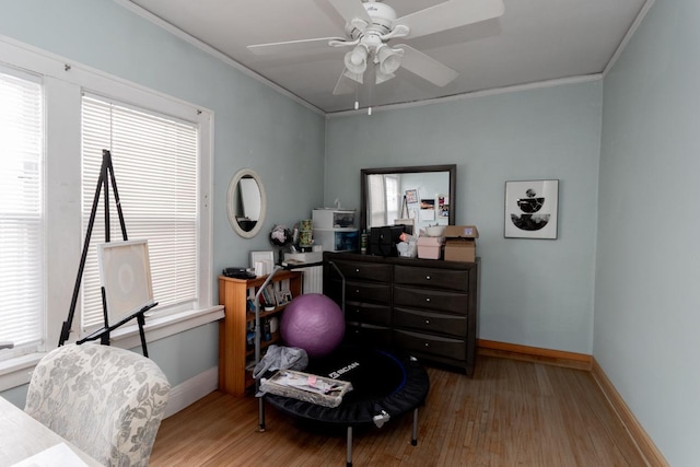 bedroom featuring baseboards, wood finished floors, and crown molding
