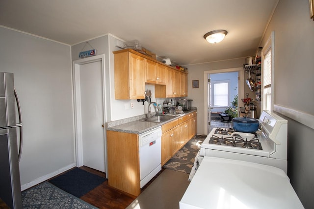 kitchen featuring white appliances, light countertops, and a sink
