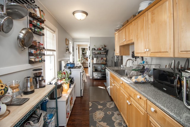 kitchen with white appliances, light brown cabinets, dark wood finished floors, and a sink