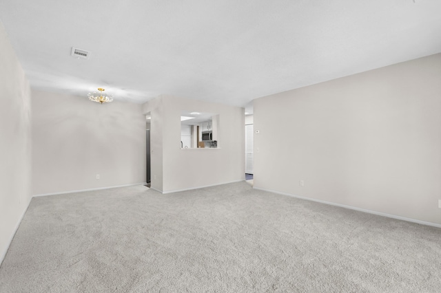 carpeted empty room with visible vents and baseboards