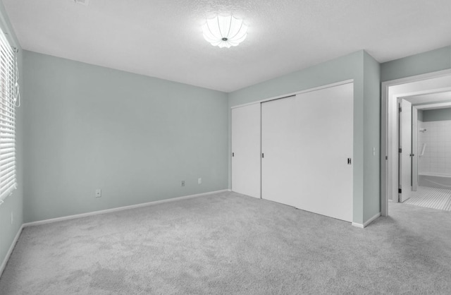 unfurnished bedroom featuring carpet flooring, a closet, and a textured ceiling