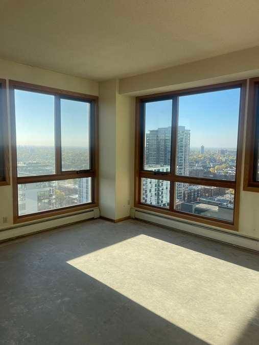 unfurnished room featuring a city view, a baseboard heating unit, baseboard heating, and concrete floors