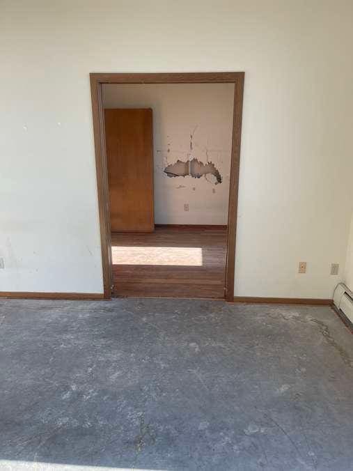 spare room featuring unfinished concrete floors and baseboards