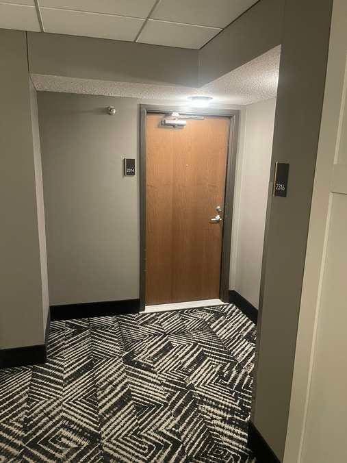 hallway with a drop ceiling and baseboards