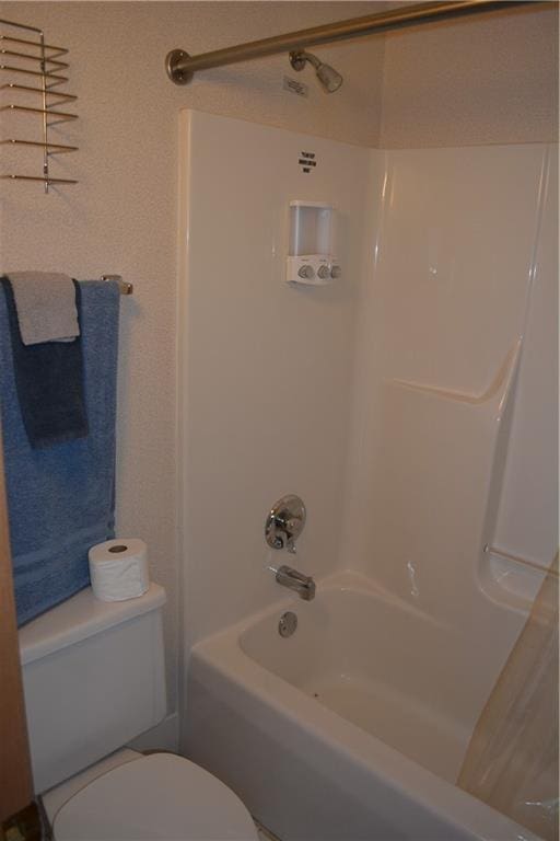 bathroom with shower / bathing tub combination and toilet