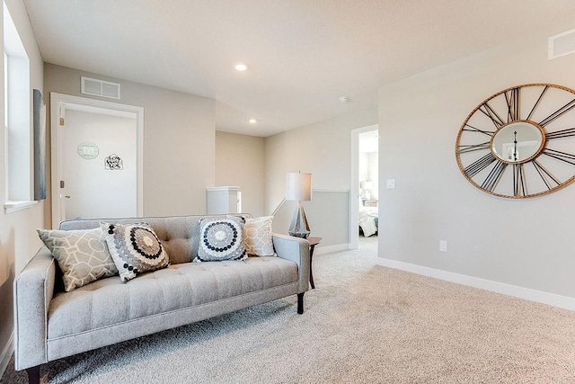 living room with light colored carpet, visible vents, and baseboards