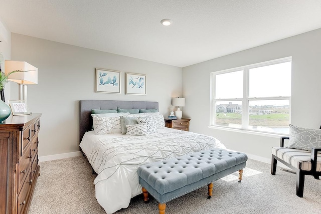 bedroom featuring light carpet and baseboards