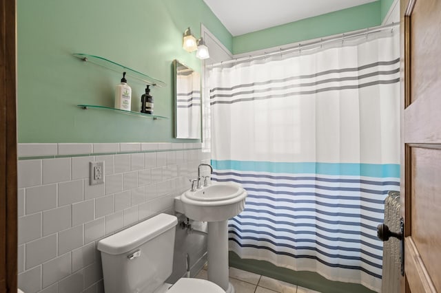 full bath with tile walls, toilet, a wainscoted wall, and tile patterned floors