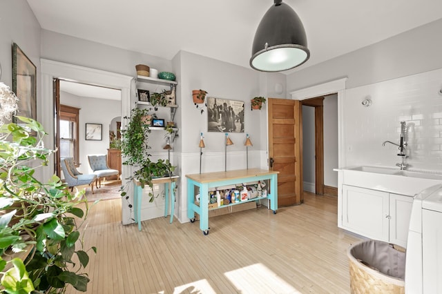 interior space with washer / clothes dryer, light wood-style floors, and a sink