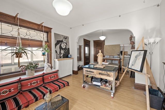 interior space with arched walkways and wood finished floors