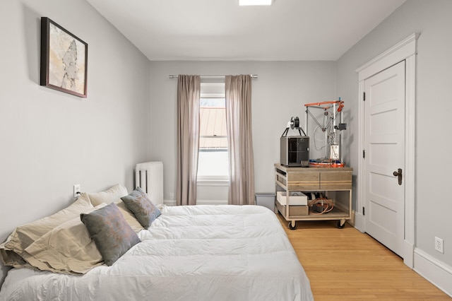 bedroom featuring radiator and wood finished floors