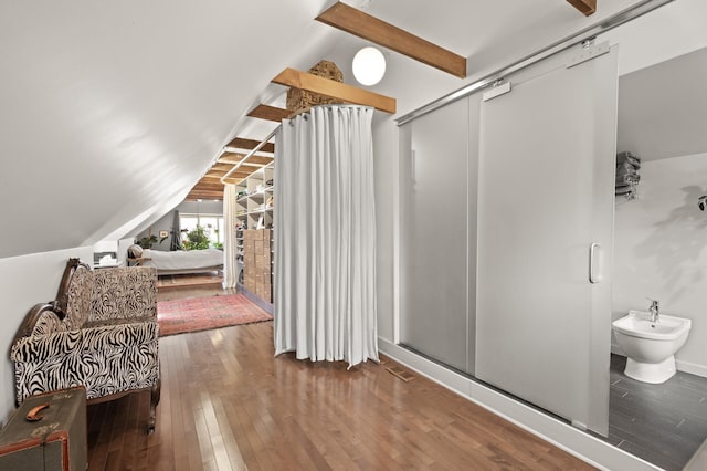 bathroom with a stall shower, vaulted ceiling with beams, a bidet, and hardwood / wood-style flooring