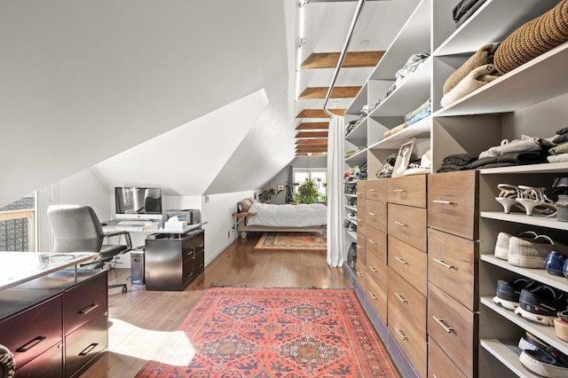 spacious closet with lofted ceiling and wood finished floors