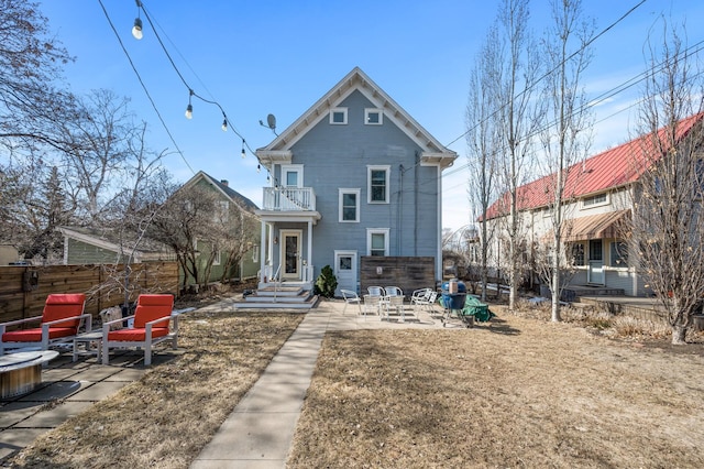 back of house featuring a patio, a balcony, and fence