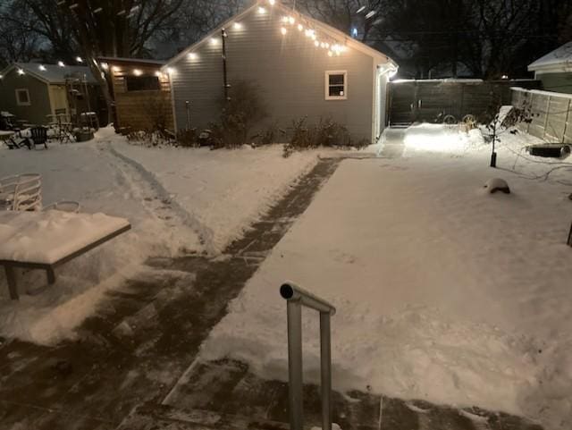 snow covered property with fence