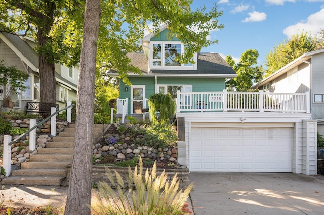 view of front of house with concrete driveway, stairs, and a shingled roof