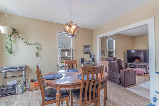 dining area featuring a notable chandelier and light wood-style flooring