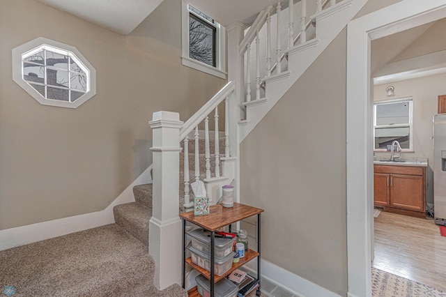 staircase featuring baseboards and wood finished floors