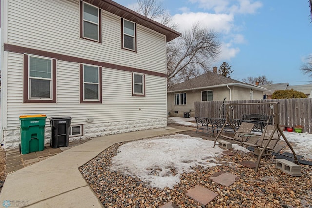 rear view of house featuring fence