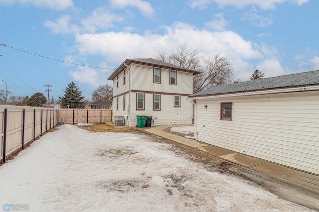 rear view of house featuring central AC unit and a fenced backyard