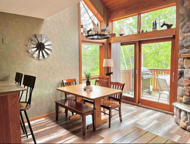 dining room featuring a notable chandelier, baseboards, and wood finished floors