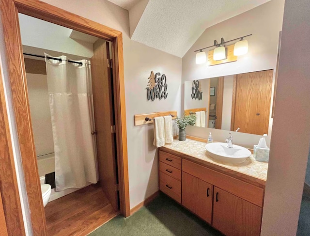 bathroom featuring a textured ceiling, lofted ceiling, toilet, vanity, and shower / bath combo with shower curtain