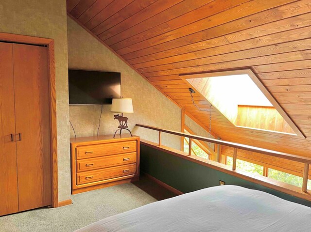 bedroom with lofted ceiling with skylight, wood ceiling, and carpet flooring