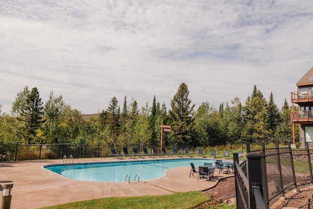 community pool featuring a patio and fence