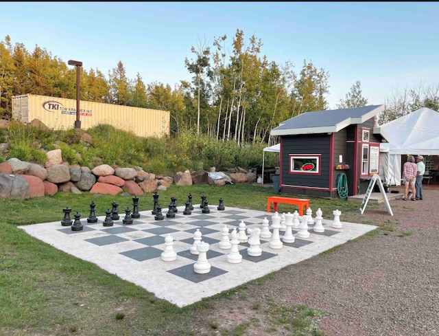 view of community with an outdoor structure, fence, and exterior structure