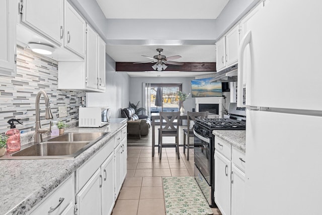 kitchen with light tile patterned floors, tasteful backsplash, white cabinetry, a sink, and white appliances