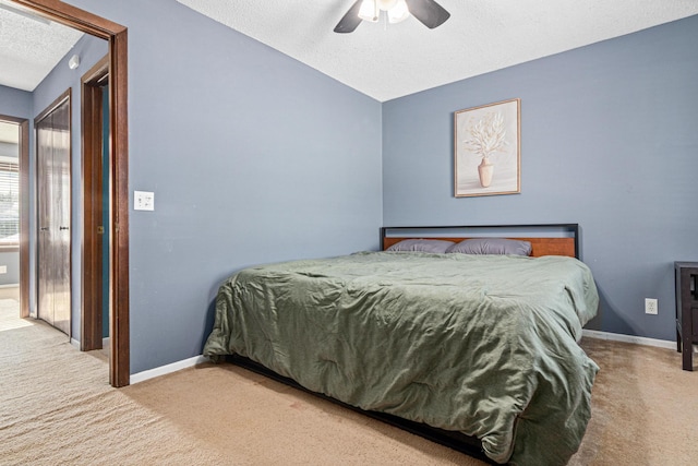 carpeted bedroom featuring a textured ceiling, a ceiling fan, and baseboards