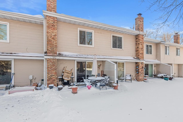 snow covered property featuring a chimney