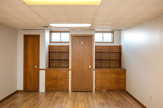 spare room with plenty of natural light, wood finished floors, and baseboards