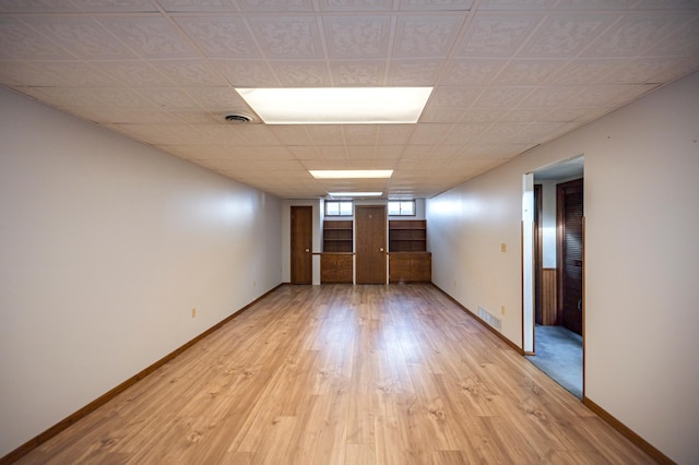 spare room with visible vents, light wood-style flooring, and baseboards