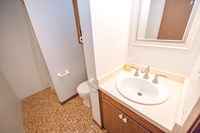 bathroom featuring vanity, toilet, and baseboards