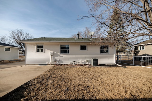 back of property featuring cooling unit and fence